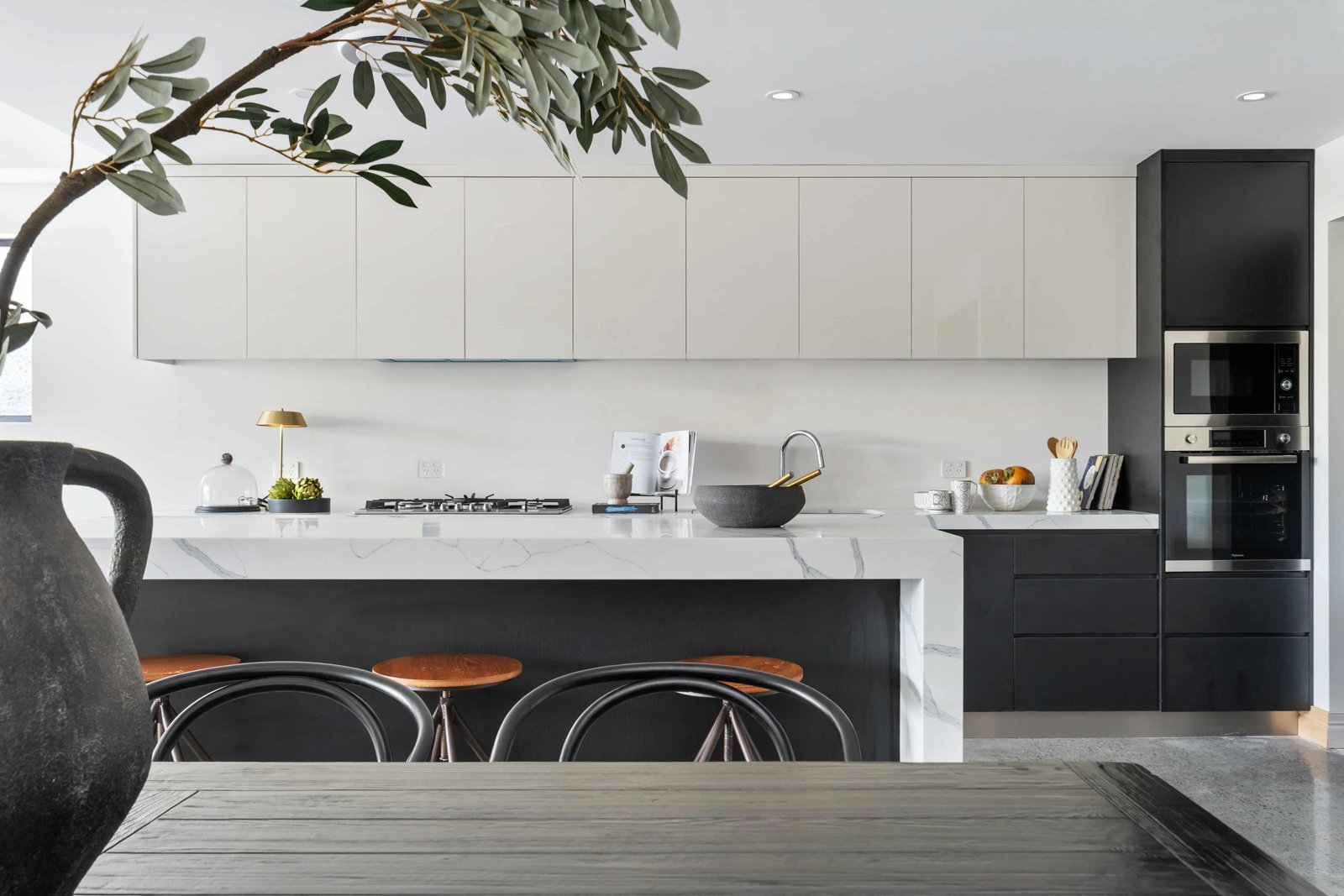 Kitchen extension with black cabinets and tree in the foreground