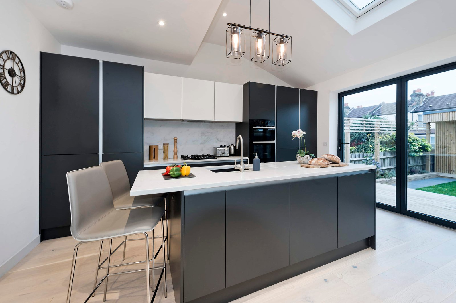 Fieldend Road - Kitchen Extension. Kitchen island, bifold patio doors facing garden.